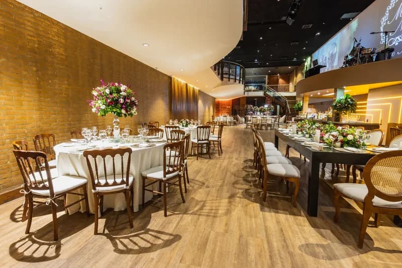 Salão com mesas postas para uma festa de casamento